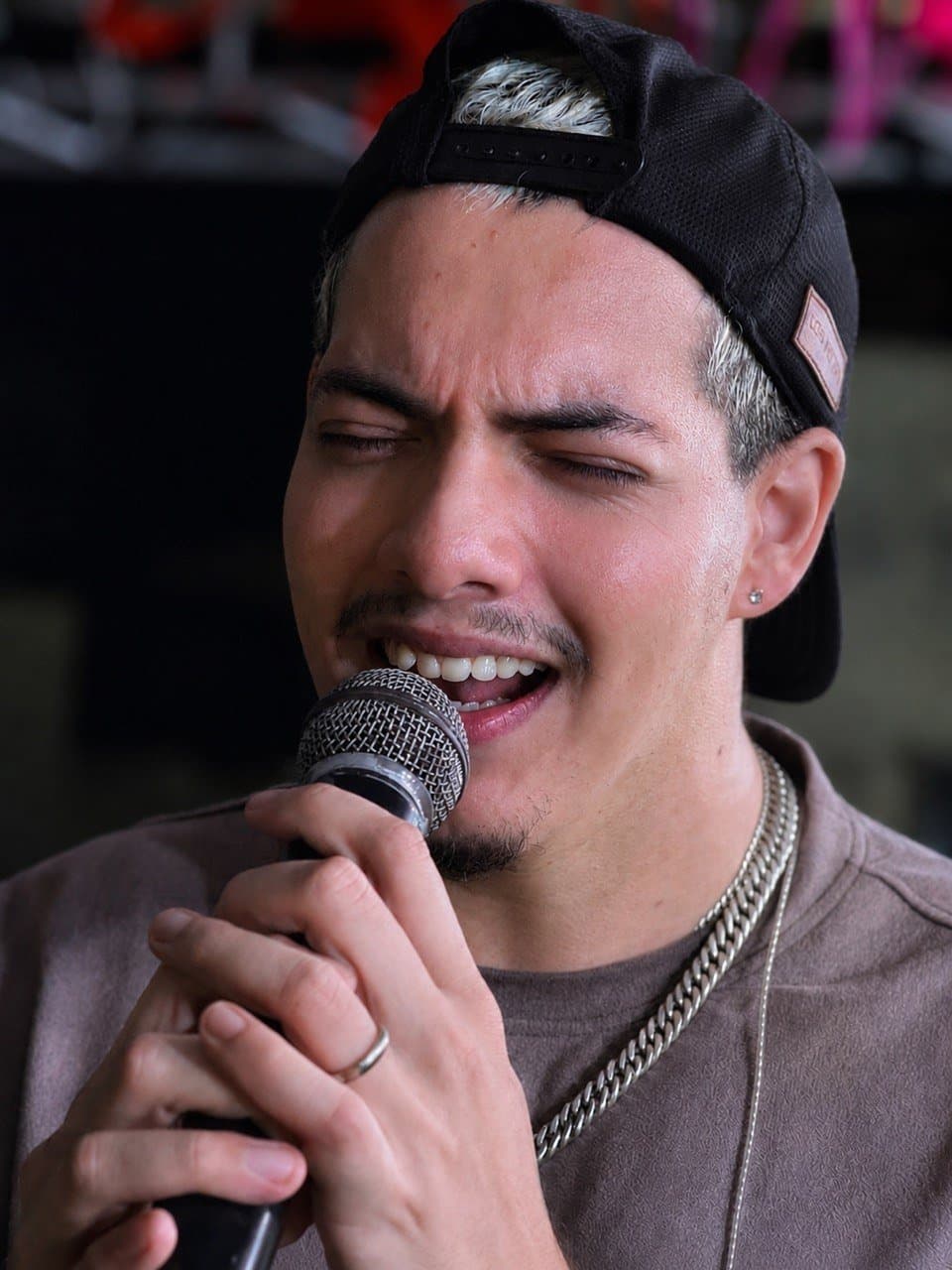 Felipe Stan em close cantando no microfone